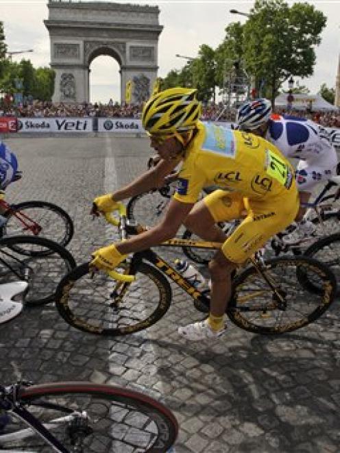 Alberto Contador of Spain, wearing the overall leader's yellow jersey, rides past the Arc de...