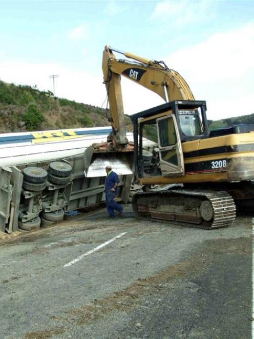 Alex McLellan, of Balclutha, watches yesterday as a tractor excavator is used to pull the crashed...