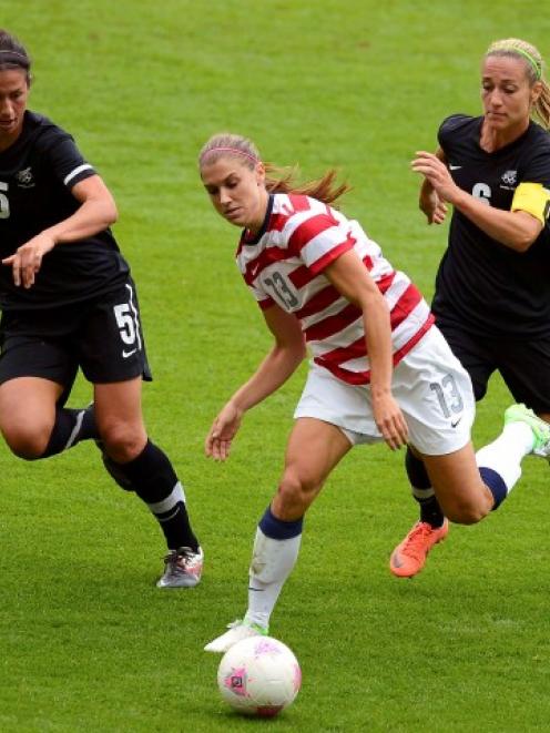 Alex Morgan (C), of the US, is chased by New Zealand's Abby Erceg (L) and Rebecca Smith during...