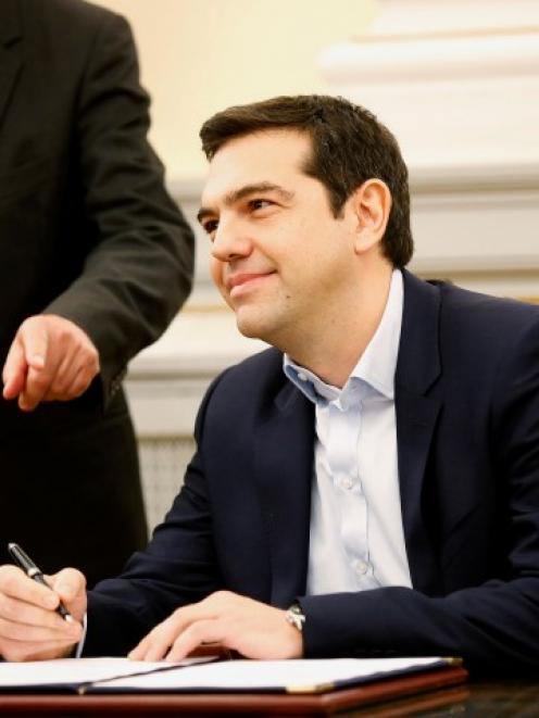 Alexis Tsipras, Syriza party leader and winner of the Greek parliamentary elections, signs papers...
