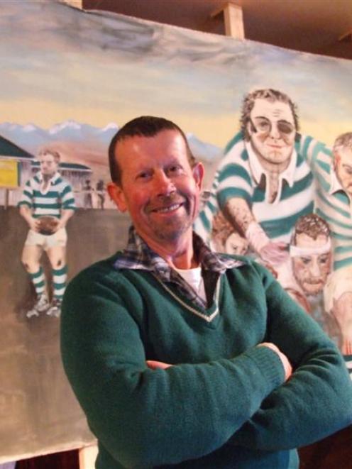 Ali Kingan with the mural he created for the Enfield Rugby Club's reunion. Mr Kingan is wearing...