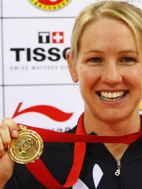Alison Shanks, of New Zealand, shows off her medal after winning the women's individual pursuit...