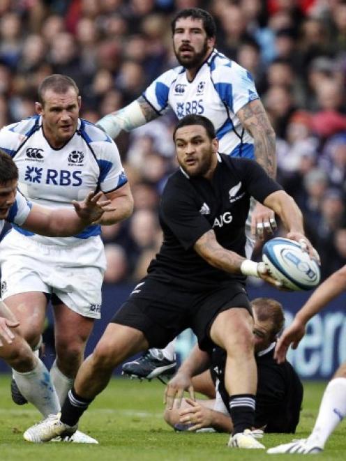 All Black halfback Piri Weepu looks to pass as Scotland players challenge during their test at...