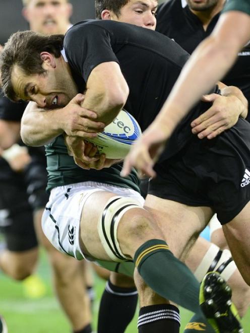 All Black midfielder Conrad Smith is caught by a Springboks tackler during their test match at...