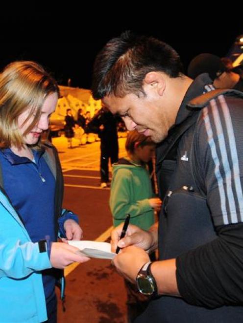 All Blacks hooker Keven Mealamu signs an autograph for Dunedin rugby fan Erin McHenry (12), while...