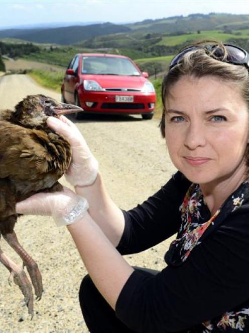 Alli Cunningham holds a weka near the spot where she hit it while driving in McIntosh Rd, in...