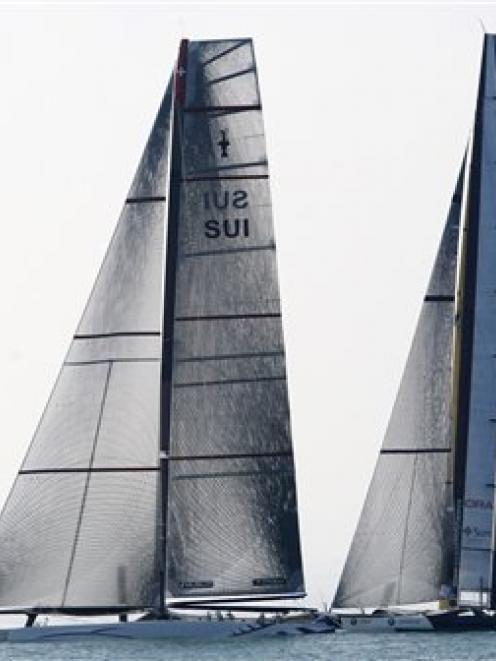 American BMW Oracle BOR 90, right, and Swiss defender Alinghi 5, left, sail at the start of the...