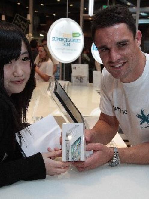 Ami Yang buys her iPhone4 S from All Black Dan Carter at Telecom's Victoria St store in central...