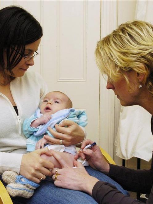 Amity Health Centre practice nurse Pauline Lovelock inoculates Nicholas Hayes (13 weeks), one of...