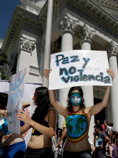 An activist of the Humanist party holds up a sign reading in Spanish: "Peace and No Violence",...