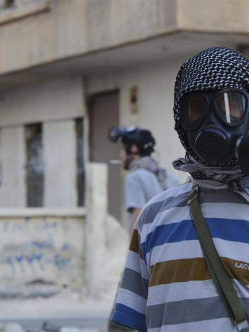 An activist wearing a gas mask is seen in the Zamalka area, where activists say chemical weapons...