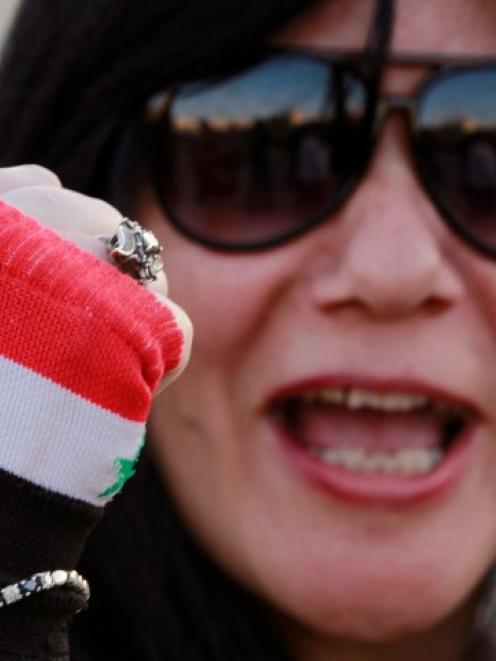 An activist wearing a glove in the colours of the Syrian flag shouts slogans against Israel...