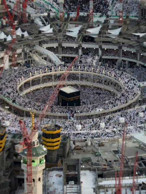 An aerial view shows Muslim worshippers praying at the Grand mosque surrounded by construction...