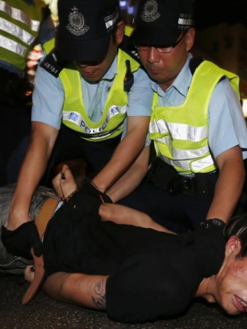 An anti-Occupy Central protester is restrained by policemen after he broke through a cordon line,...