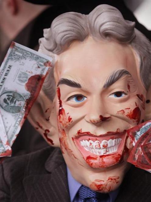 An anti-war demonstrator, dressed as bloodied former British prime minister Tony Blair, stands...
