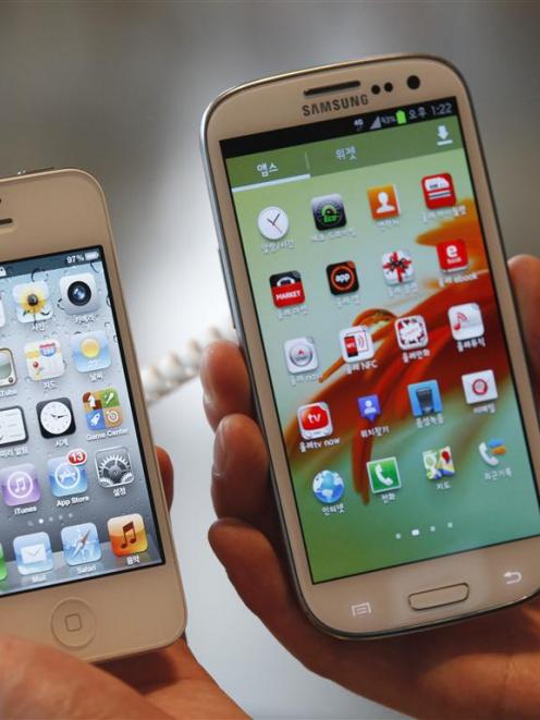 An Apple iPhone 4S (left) and a Samsung Galaxy S III. REUTERS/Lee Jae-Won