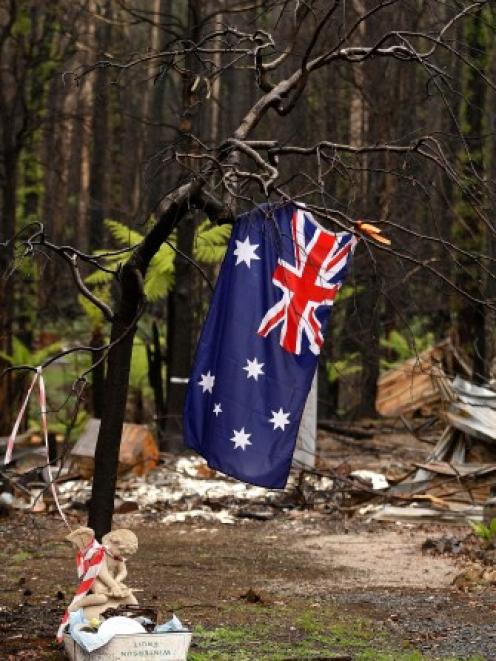An Australian flag hangs from a tree in Marysville, Victoria on the three-month anniversary of...