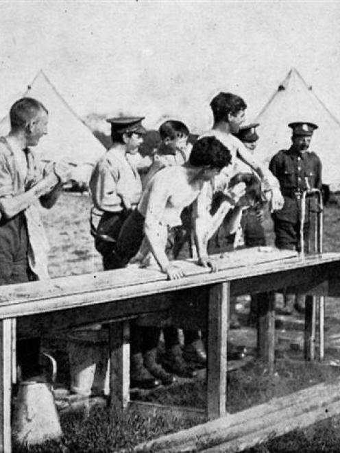 An early morning shower at a British training camp, where the troops rise at 5.30 a.m. in a...