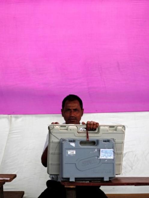 An election official holds an Electronic Voting Machine before handing it over to the polling...