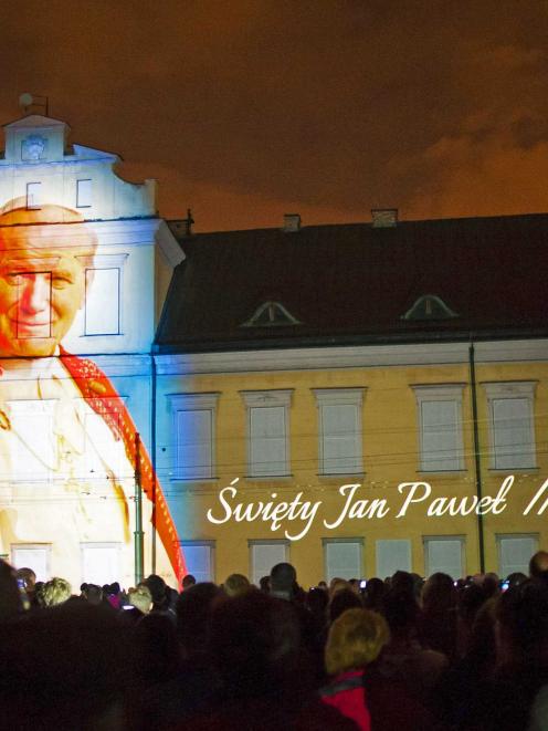 An image of Pope John Paul II is projected during a multimedia show a night before his...