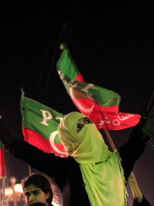 An Imran Khan supporter cheers while listening to him speak during what has been dubbed a ...