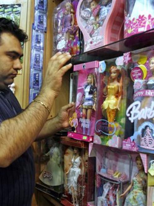 An Iranian shopkeeper displays dolls at his toy shop in Teheran. Police have closed down dozens...