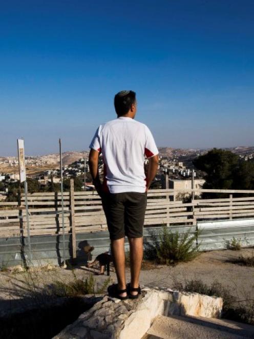 An Israeli man takes part in a ceremony announcing the resumption of construction of an Israeli...