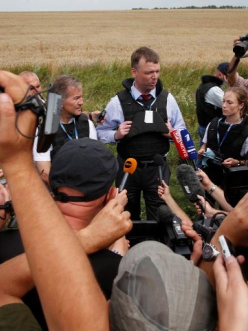 An Organisation for Security and Cooperation in Europe monitor speaks to journalists at the crash...