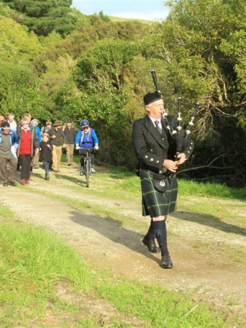 Andrew McColm (left) and Gordon Watson, of the Dunedin City Pipe Band, lead a group of 80 walkers...