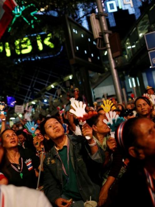 Anti-government protesters listen to a leader's speech as they occupy a major intersection in...