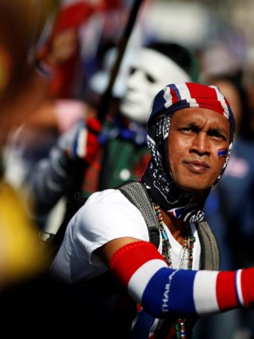 Anti-government protesters wave flags as they march through Bangkok's financial district. REUTERS...