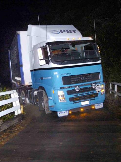 Antony Behr, of Peter Baker Transport, waits to have his truck moved after it got stuck on...