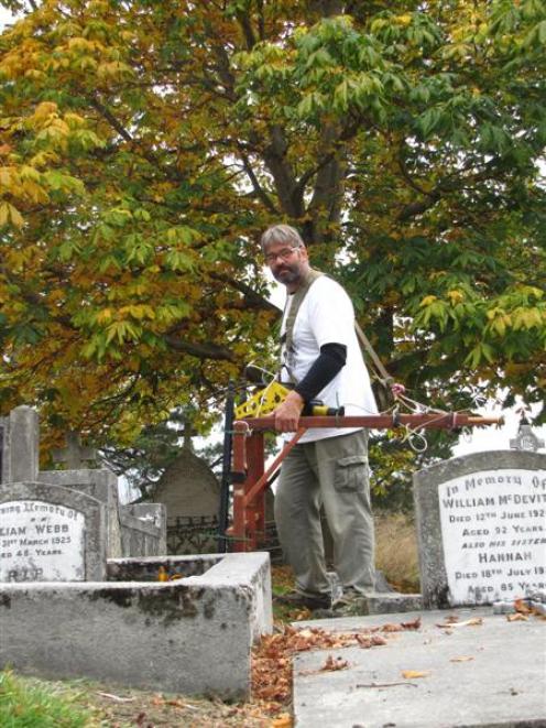 Archaeologist Hans-Dieter Bader uses ground penetrating radar to find unmarked graves in the St...