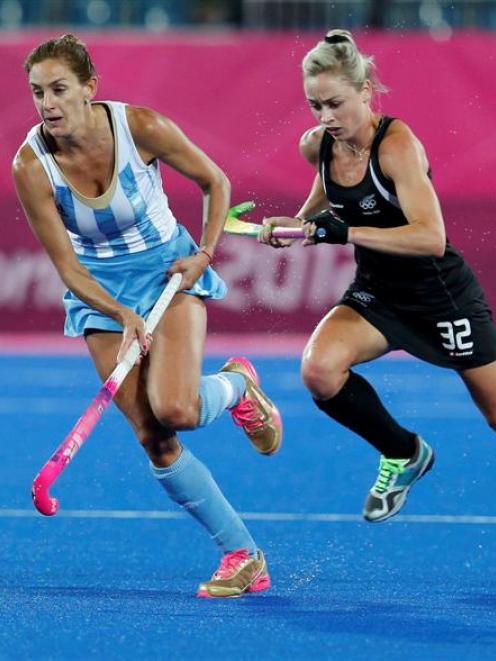 Argentina's Luciana Aymar is challenged New Zealand's Anita Punt.   REUTERS/Mike Hutchings