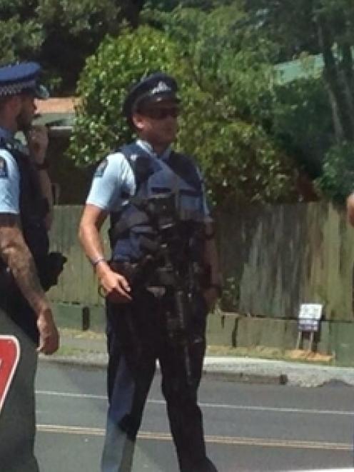 Armed police lock down an area of Takanini yesterday after the carjacking at gunpoint.