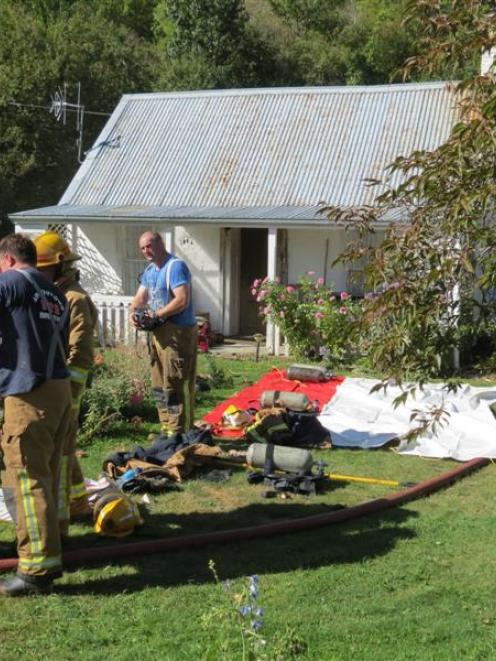 Arrowtown and Frankton firefighters used breathing apparatus to enter a small cabin behind this...