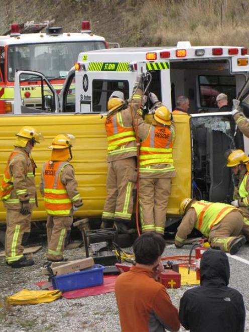 Arrowtown and Frankton volunteer fire brigade members use the jaws of life to extract the male...