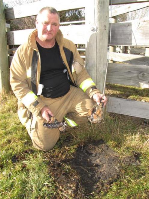 Arrowtown Fire Chief Garry Hall holds two pieces of earth, which were turned into glass when an...