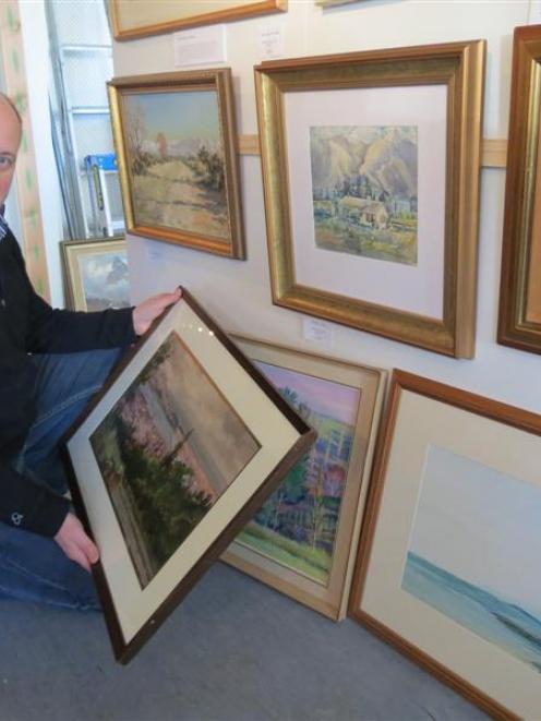 Arrowtown Gallery manager Simon Beadle admires newly released original artworks by  deceased...