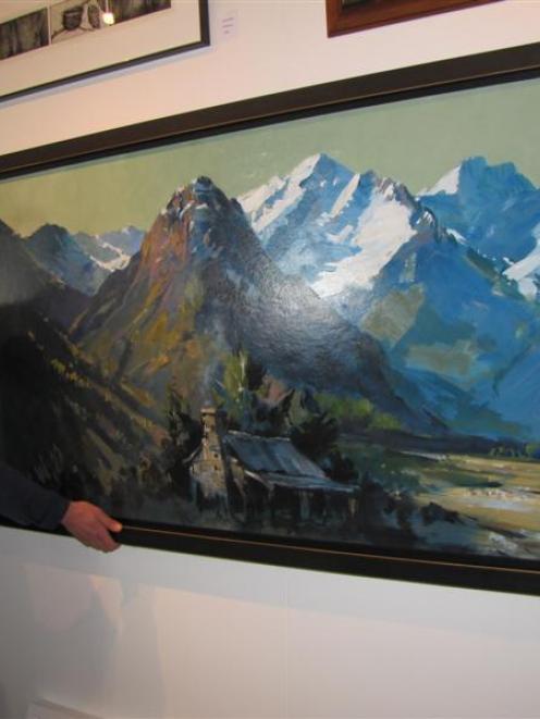 Arrowtown Gallery manager Simon Beadle admires the large original oil on board landscape by the...