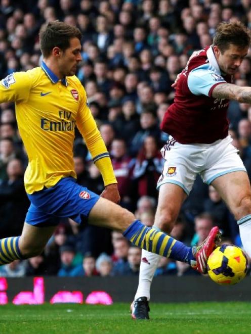 Arsenal's Aaron Ramsey (L) challenges West Ham United's George McCartney. REUTERS/Suzanne Plunkett