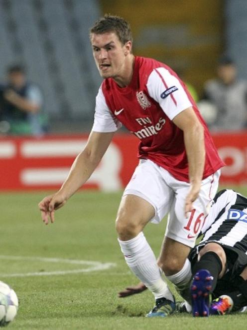 Arsenal's Aaron Ramsey (L) fights for the ball with Giampiero Pinzi of Udinese during their...