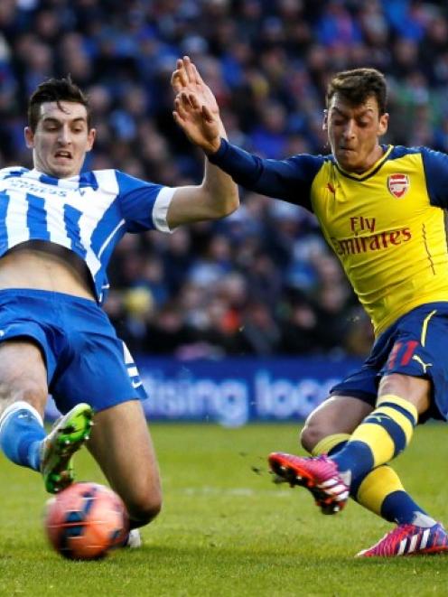 Arsenal's Mesut Ozil (R) shoots to score against Brighton and Hove Albion during their FA Cup...