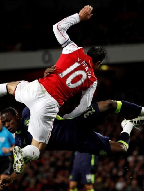 Arsenal's Robin van Persie (L) challenges Wigan Athletic's Maynor Figueroa during their Premier...