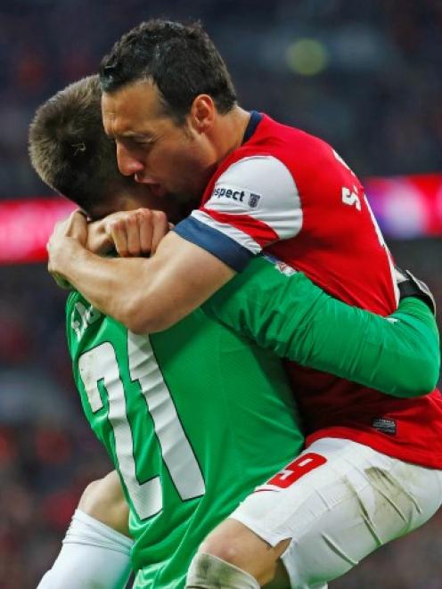 Arsenal's Santi Cazorla (R) celebrates with goalkeeper Lukasz Fabianski after scoring the winning...