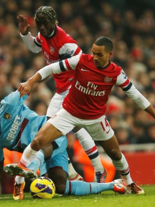 Arsenal's Theo Walcott (R) is challenged by West Ham's Carlton Cole during their English Premier...
