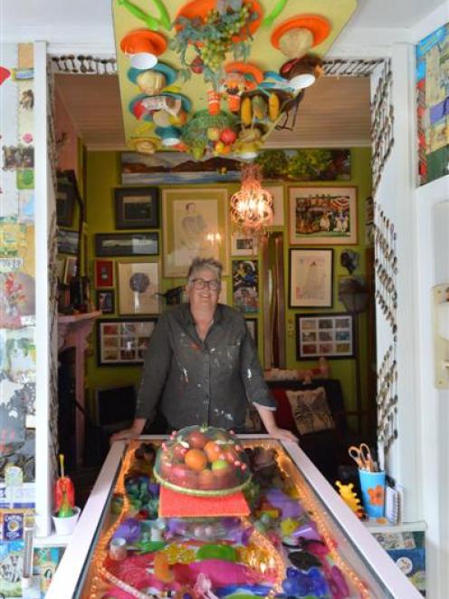 Artist Janet de Wagt beneath the upside-down dinner setting in her lounge. Photo by Gerard O'Brien.
