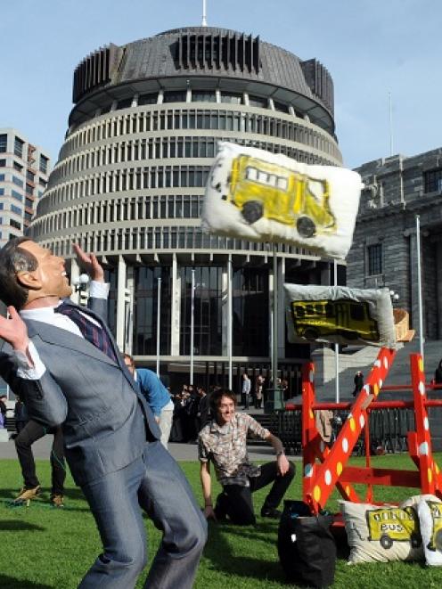 Artists using a mock catapult and a George Bush mask seek to raise awareness of the raids against...