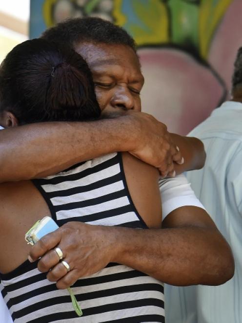Attendees hug at a church service for eight children who were killed in the Cairns suburb of...