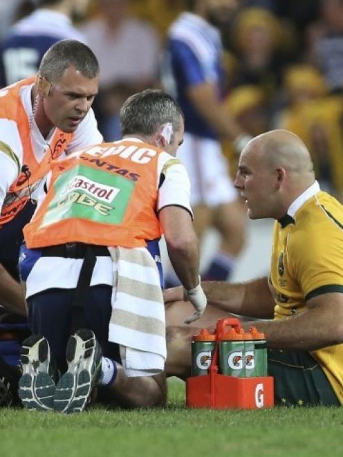 Australia captain Stephen Moore receives treatment for the injury during the match against France...